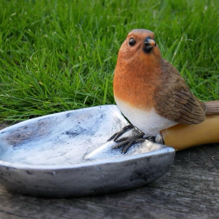 Robin bird feeder on a trowel outdoor item for the garden