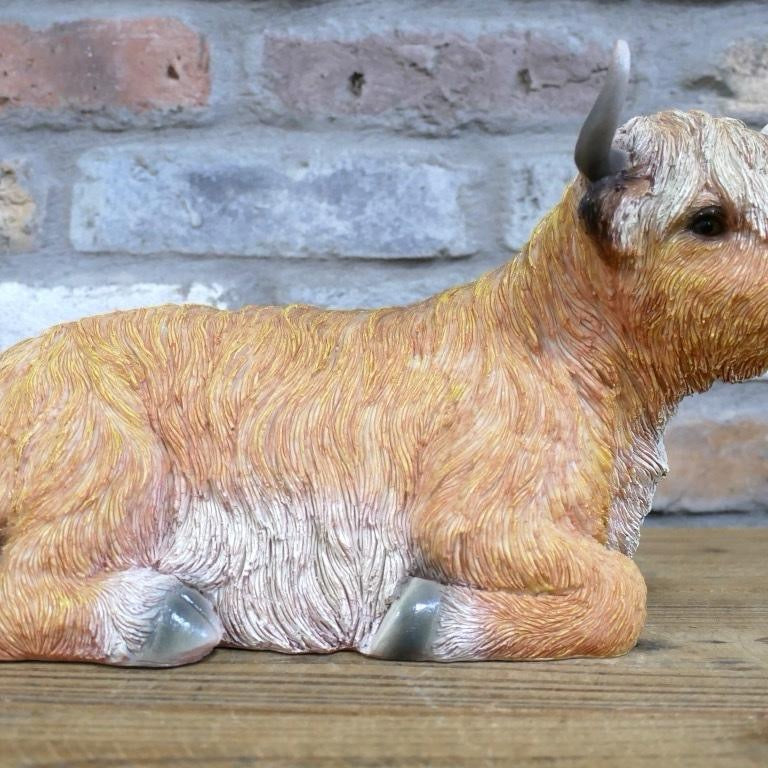 Laying down highland cow statue