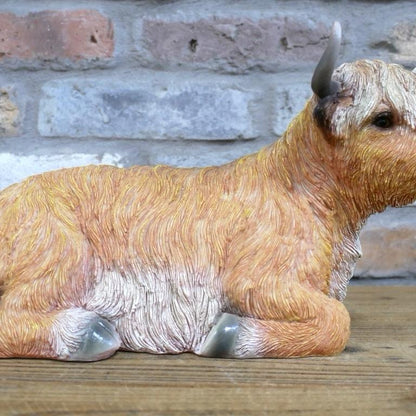 Laying down highland cow statue