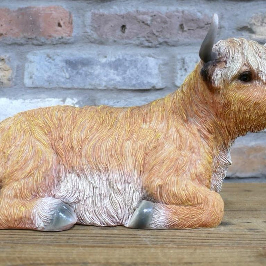 Laying down highland cow statue