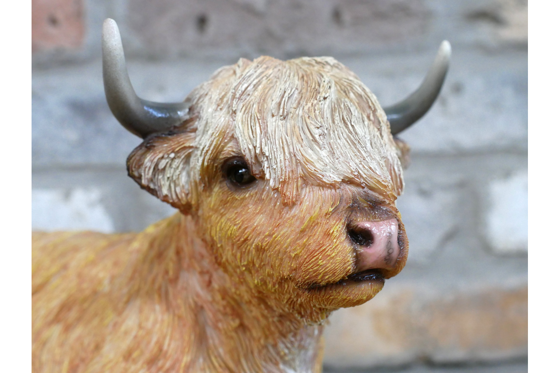 Laying down highland cow statue