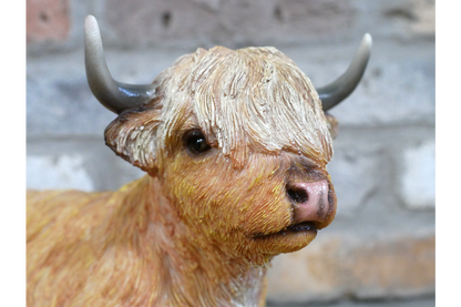 Laying down highland cow statue