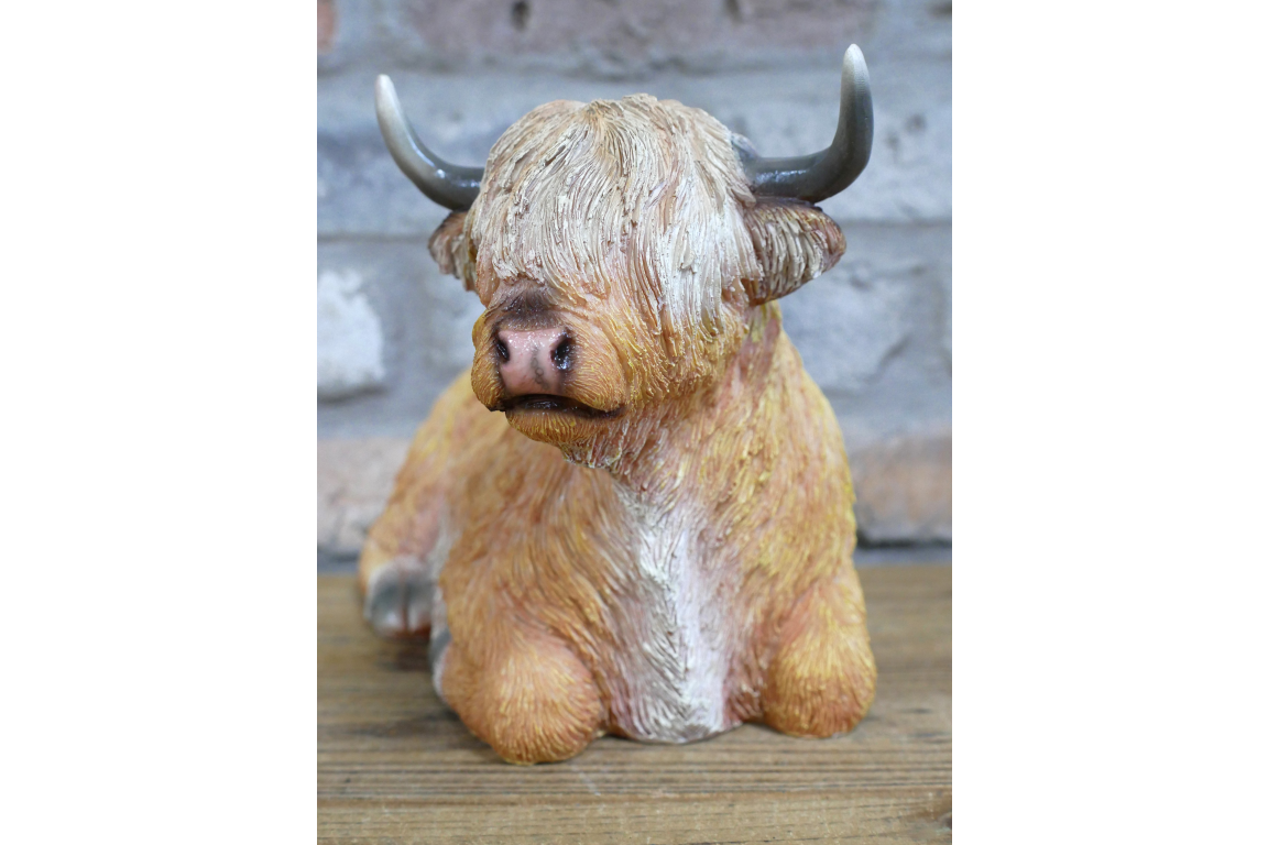 Laying down highland cow statue