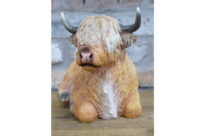 Laying down highland cow statue