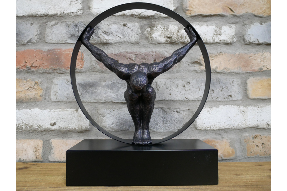 Black statue with circle detail and hanging man