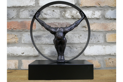 Black statue with circle detail and hanging man