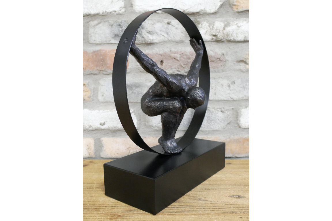 Black statue with circle detail and hanging man