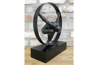 Black statue with circle detail and hanging man