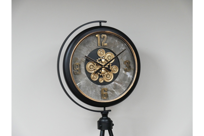 Black and gold industrial moving cog clock on a stand