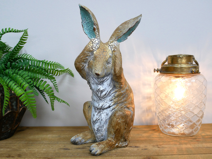 Rustic rabbit statue with hands over ears , for home or garden
