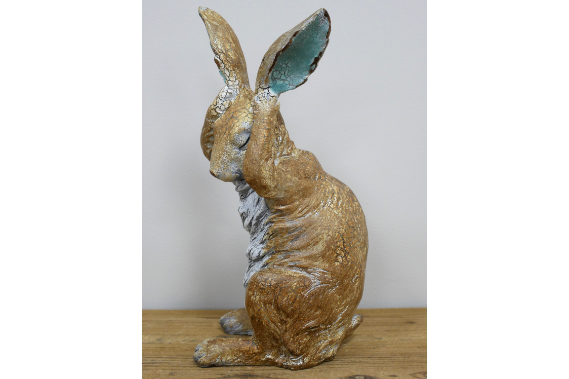 Rustic rabbit statue with hands over ears , for home or garden