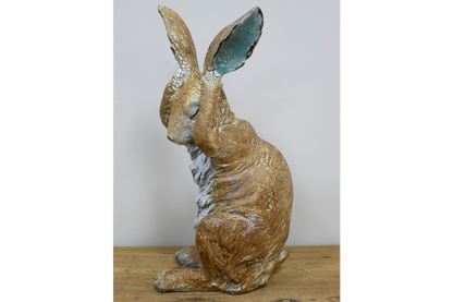 Rustic rabbit statue with hands over ears , for home or garden