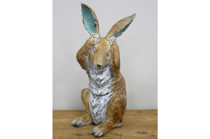 Rustic rabbit statue with hands over ears , for home or garden