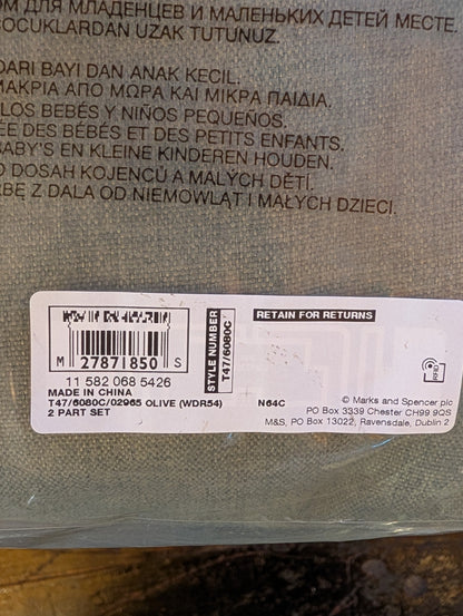 Close-up of the back of a woven fabric pouch with printed multilingual text and a white barcode label near the bottom.