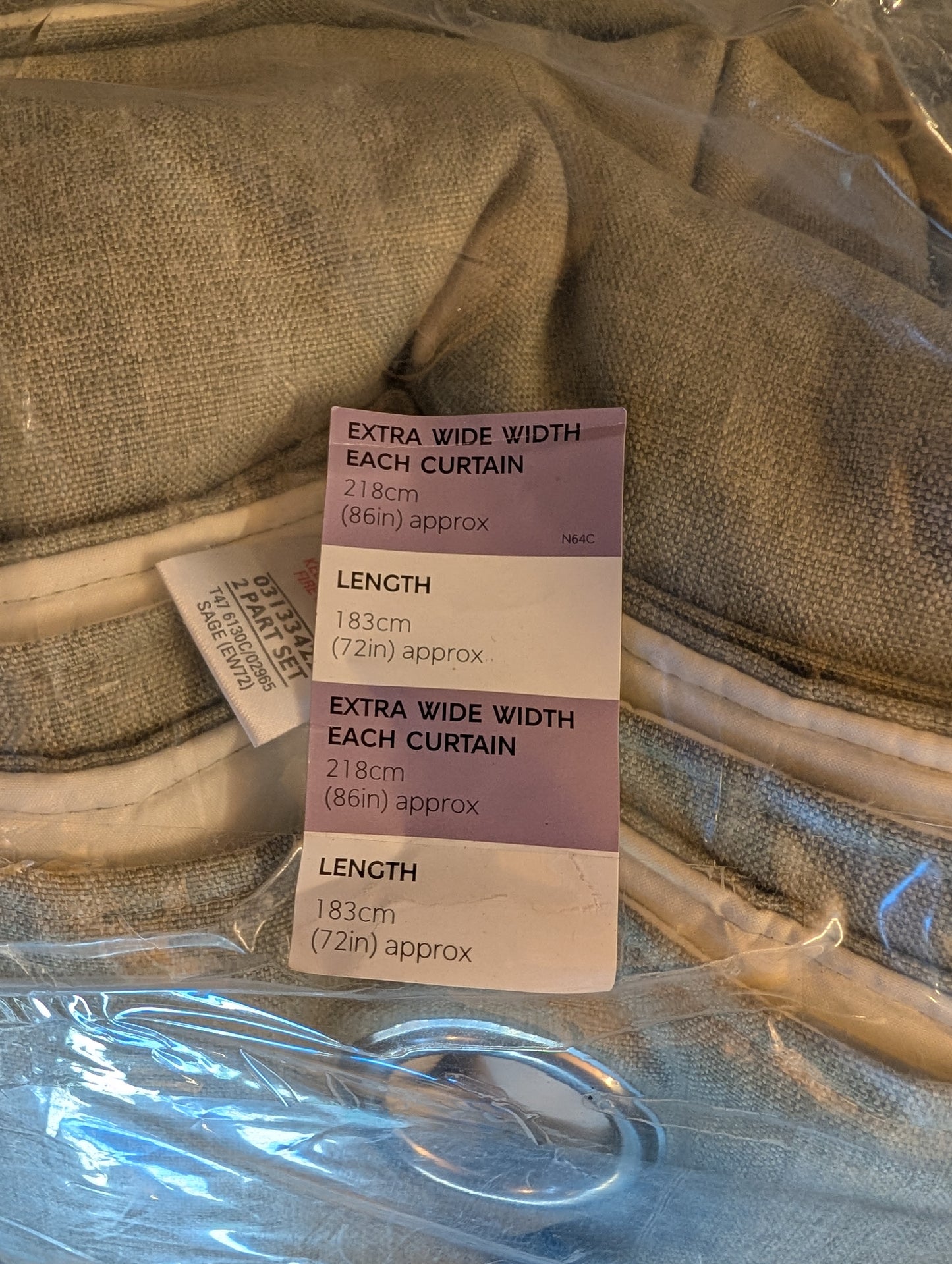 A close-up of a packaged curtain with a size tag showing measurements: each curtain is extra wide 213cm (86in) and length 183cm (72in) approx.